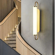Modern minimalist gold led wall lamp with cylindrical frosted glass diffuser and curved metal frame for bedroom use