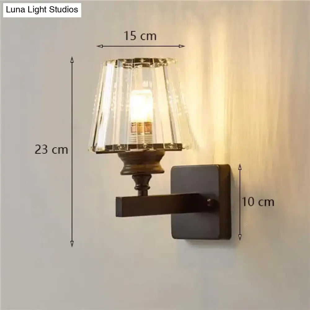 A modern minimalist wall lamp with dark bronze base and fluted crystal shade for elegant bedroom lighting