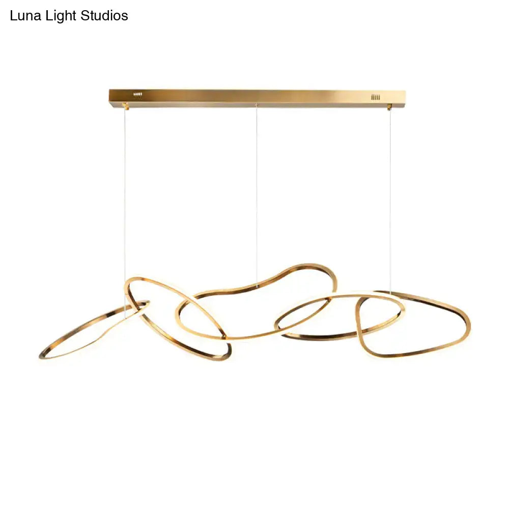 Modern minimalist golden led hanging light with sleek interlocking rings suspended from brass fixture for dining room