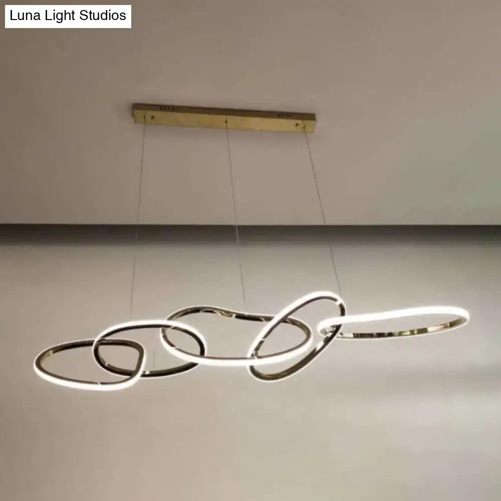 Modern minimalist golden hanging light with interlocking circular rings and sleek minimalist design for dining room