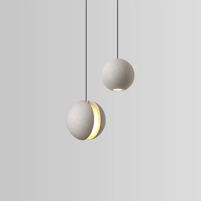 Modern minimalist gray and gold pendant light featuring cement planet chandelier design with matte gray concrete spheres and black cords