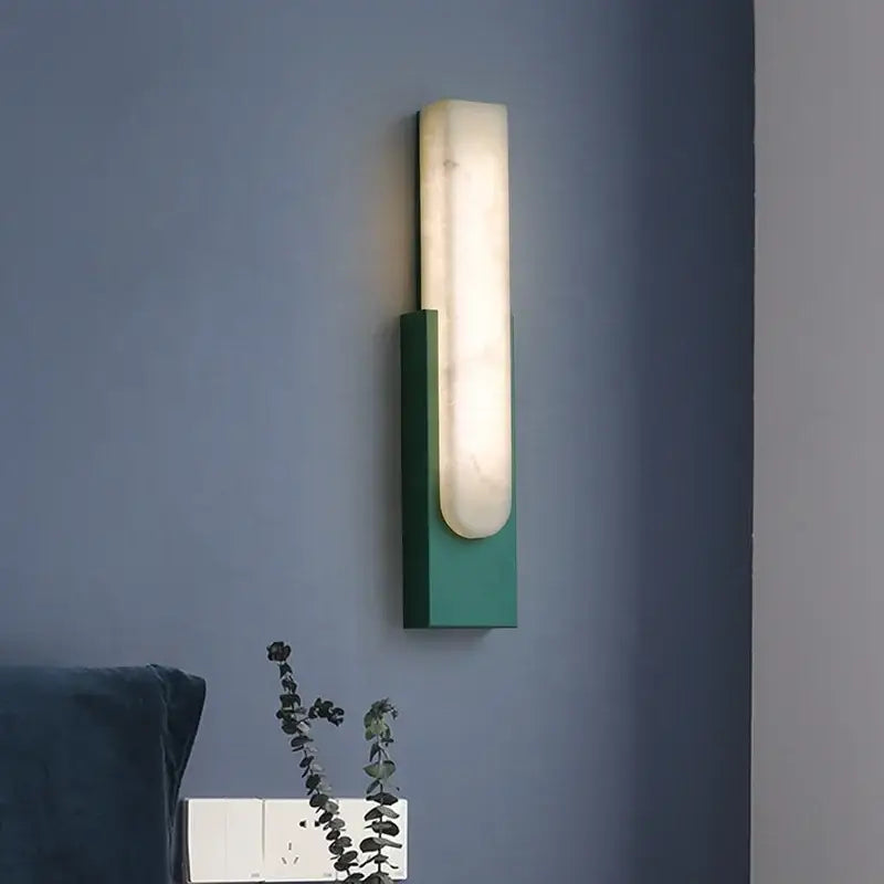 Modern minimalist grey metal led wall sconce with a sleek green metal base and illuminated white marble-like diffuser by decorbites grey metal