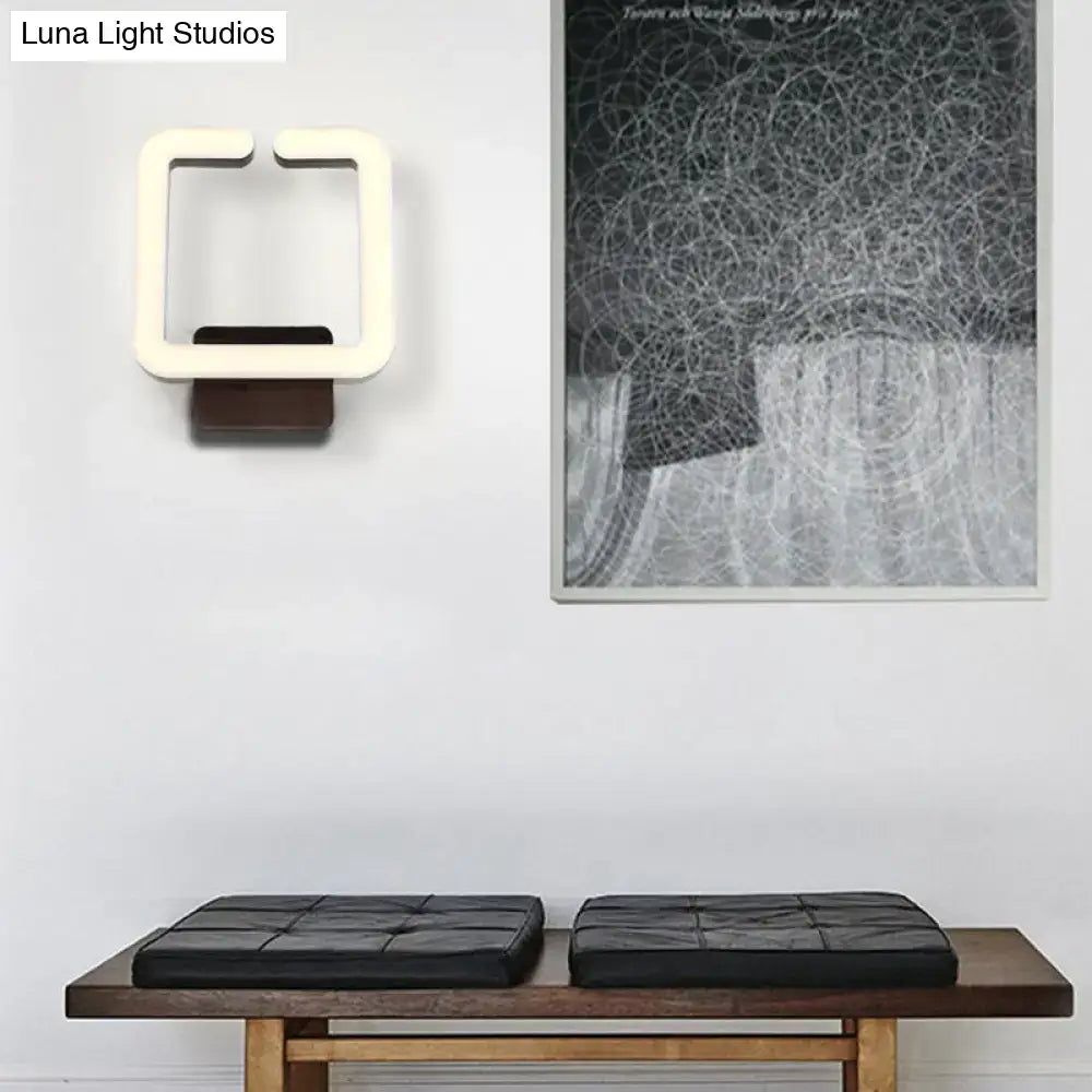 Modern off-white square LED wall sconce with dark wood base providing warm white natural light for bedroom use