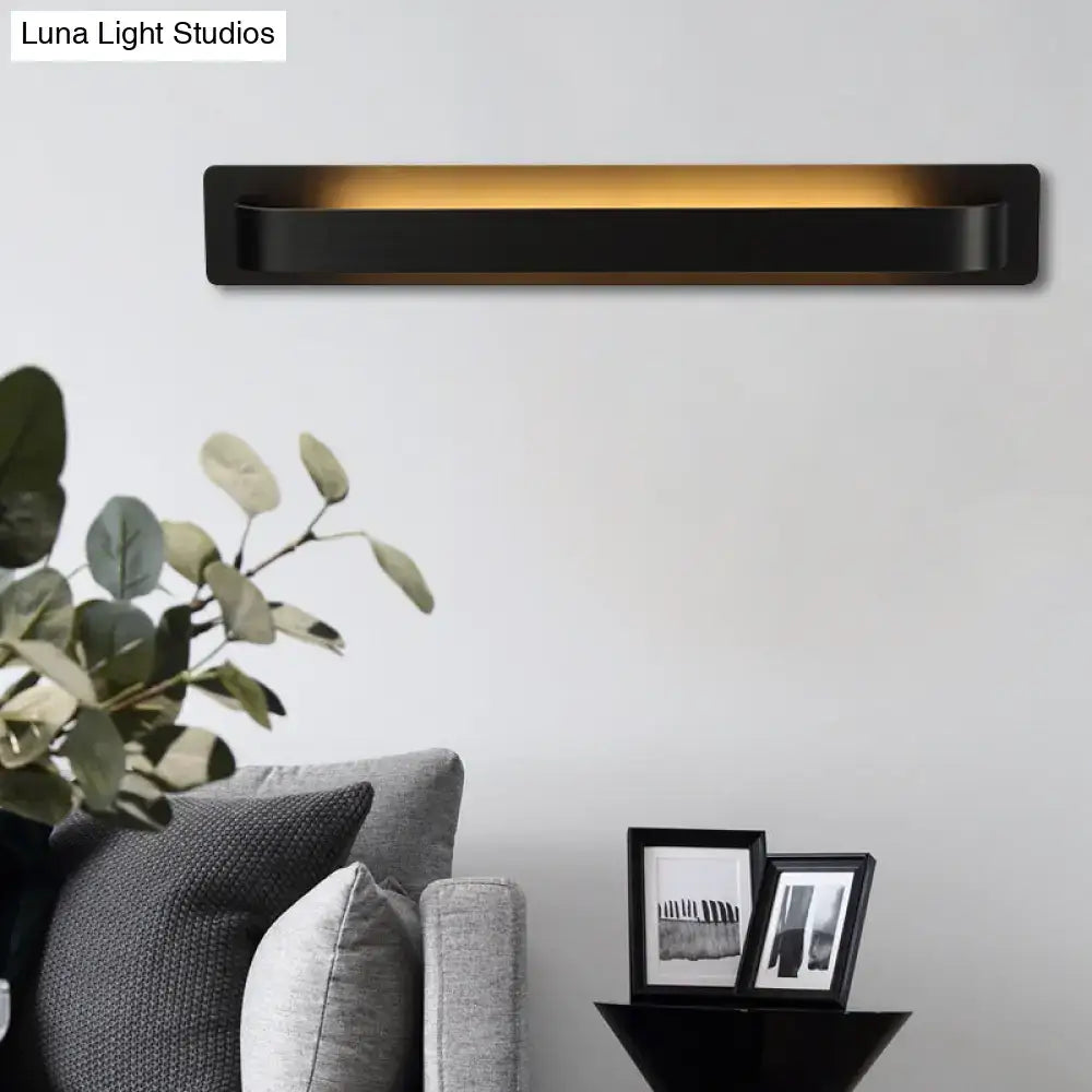 Black rectangular wall lamp with sleek modern design and warm yellow illumination for living room lighting