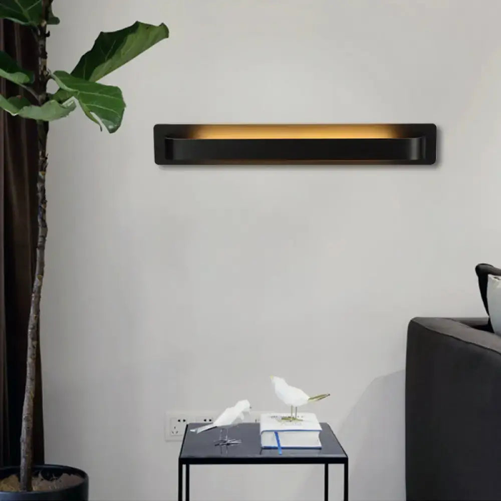 Black rectangular wall lamp with warm amber illumination modern minimalist silver linear design for living room use