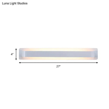 A sleek modern silver wall lamp with frosted glass diffuser and metallic frame for minimalist living room decor