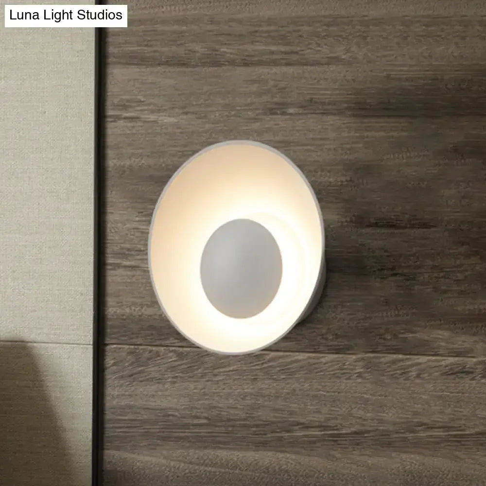 A sleek modern white wall lamp with circular design and soft ambient glow for minimalist living room décor