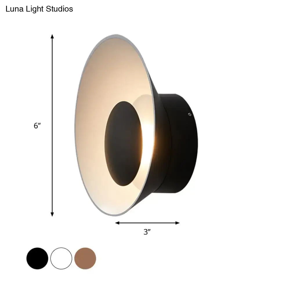 Black conical wall lamp with matte finish and warm diffused light for modern minimalist living room decor
