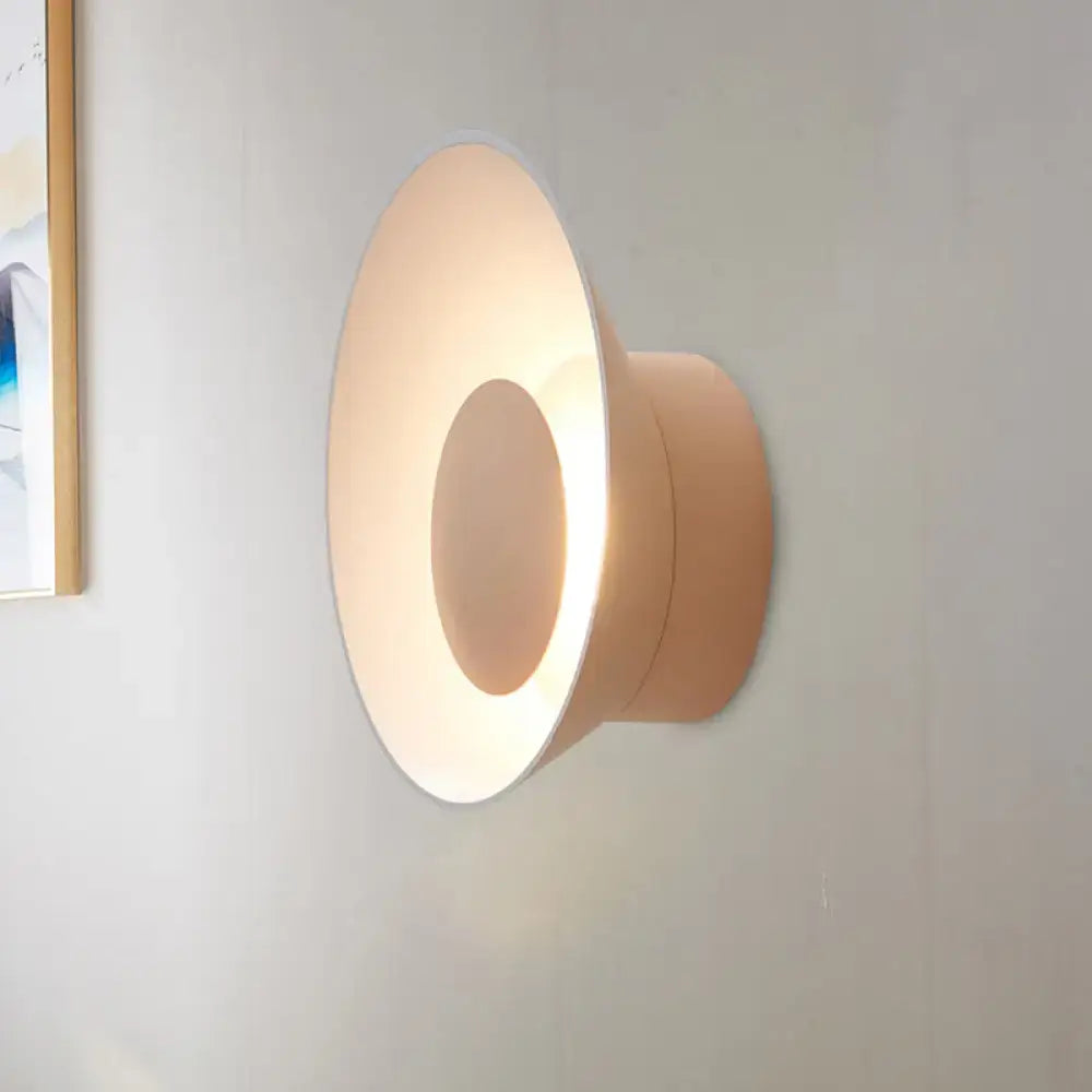 Beige conical wall lamp with softly glowing minimalist design ideal for modern living room lighting