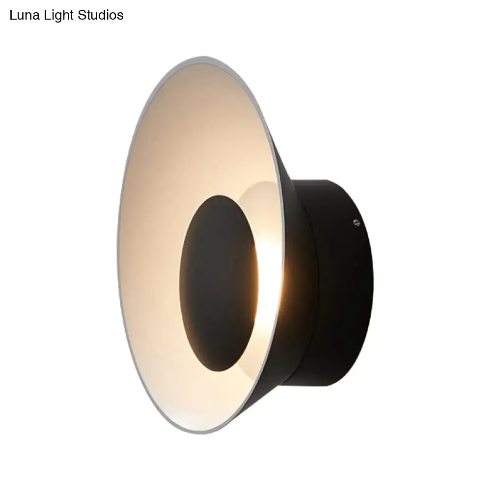 Modern minimalist black LED wall lamp with sleek circular design and warm ambient lighting for living room use