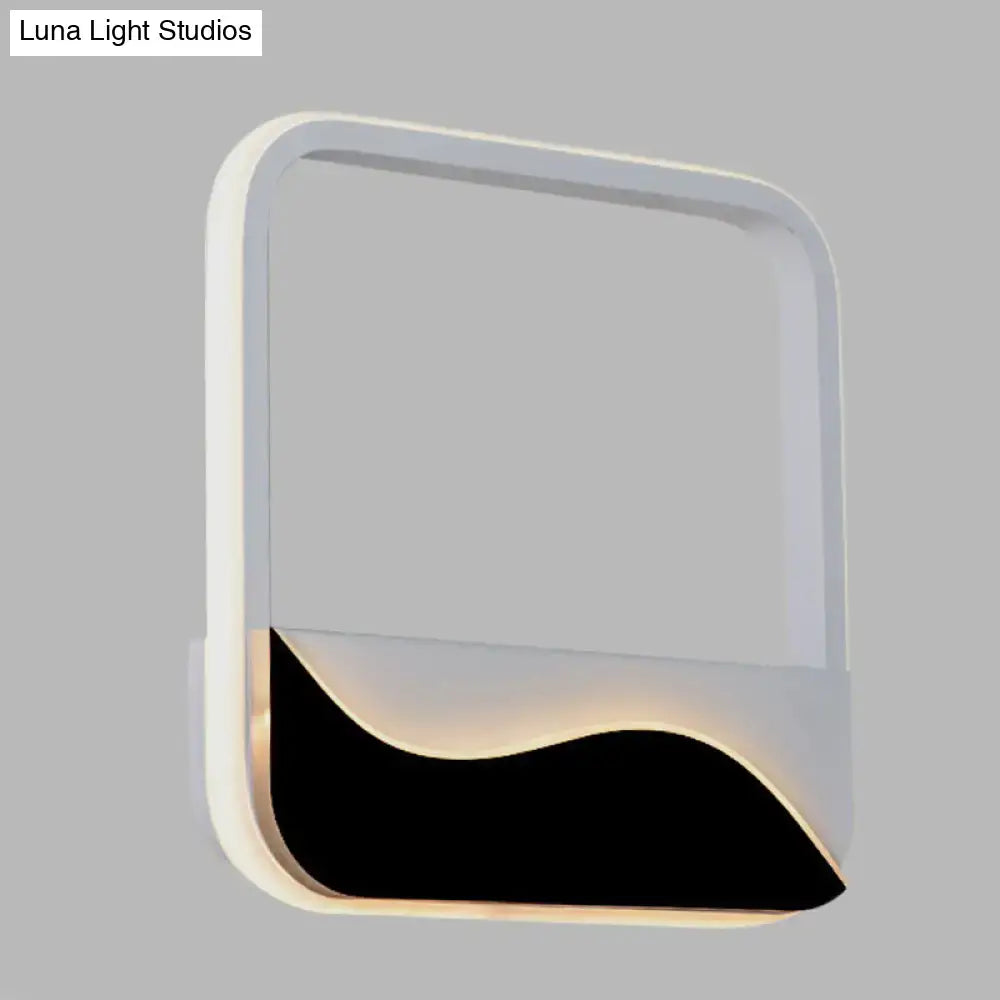 Modern minimalist white and black led wall mount sconce with sleek curved panel emitting warm white light for bedroom use