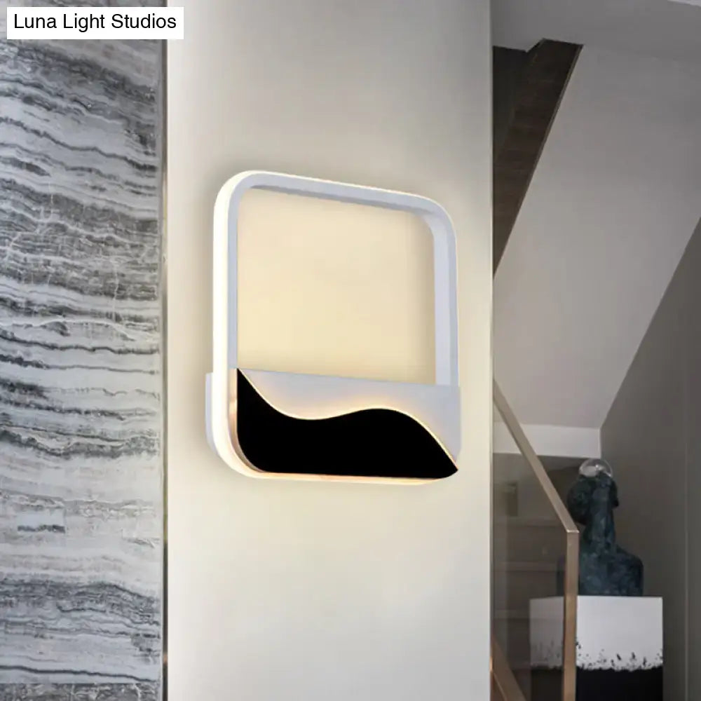 Modern minimalist white and black led wall mount sconce with curved black accent and warm white light for bedroom use