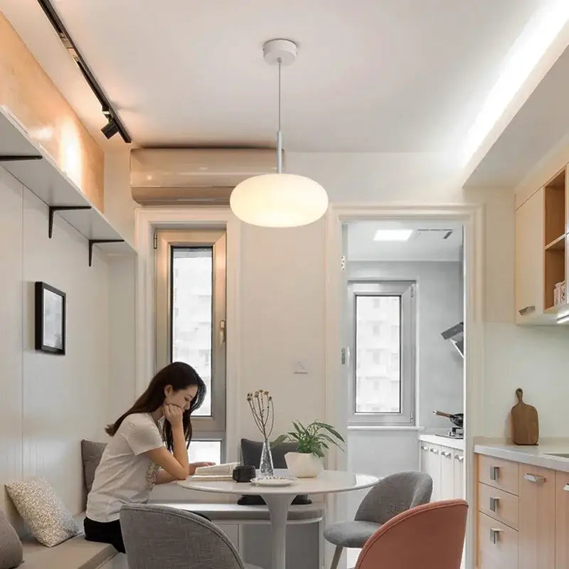 A modern white ceiling pendant lamp with sleek minimalist design for kitchen and bedroom lighting
