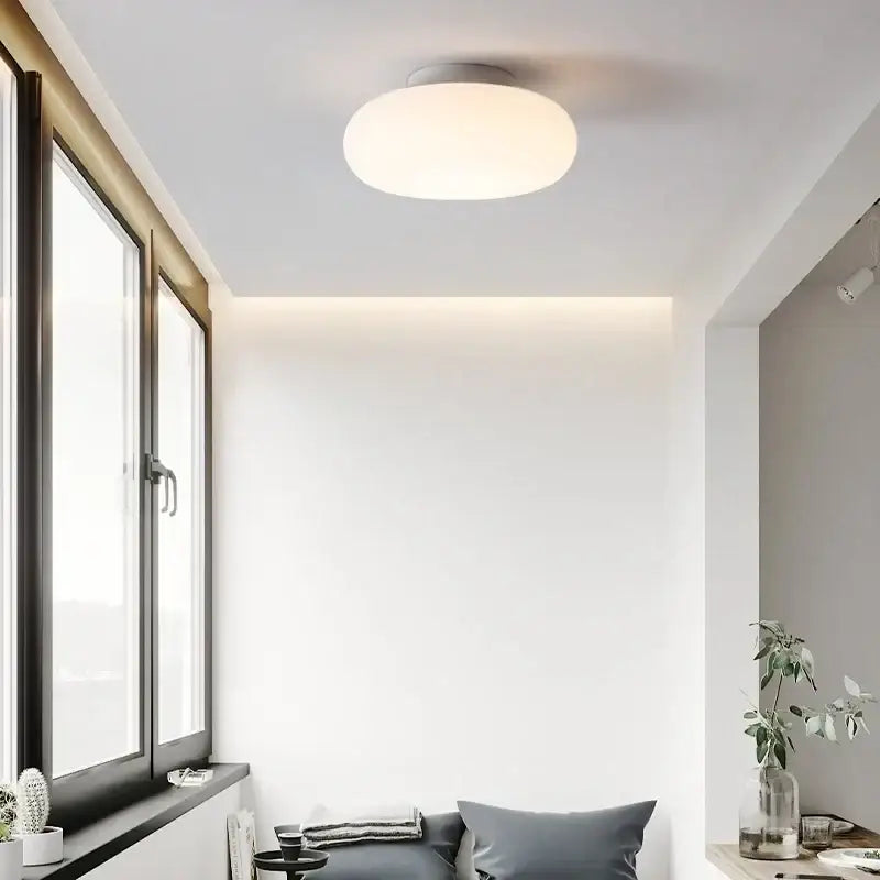 A sleek round modern minimalist white ceiling pendant lamp with a soft white diffuser for kitchen and bedroom