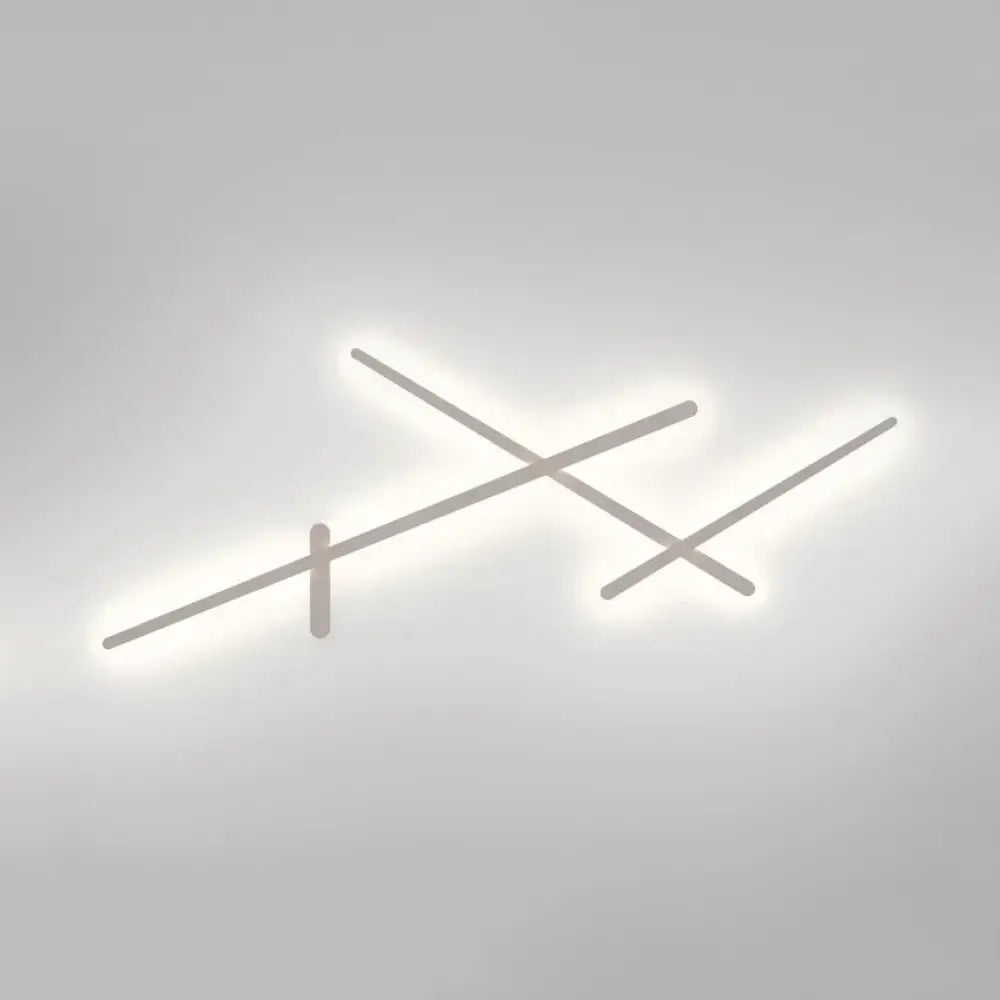 Modern minimalist white wall lamp with sleek intersecting linear arms emitting soft white LED glow for living room