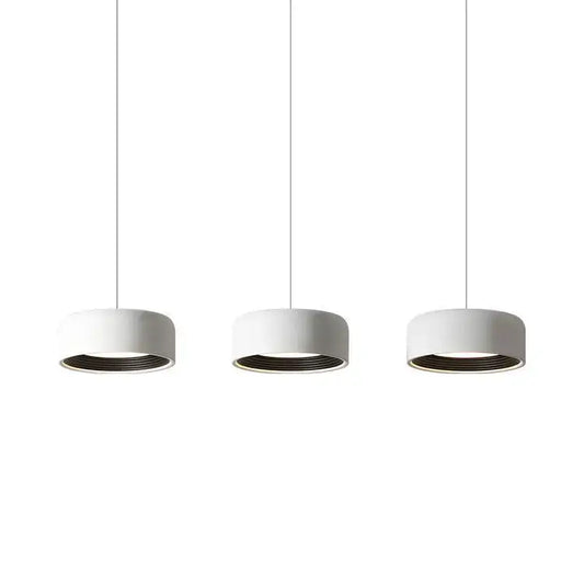 Three minimalist white cylindrical pendant lights with dark inner rims in decorbites designer led chandelier for dining room decor