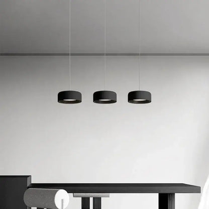 Three sleek black cylindrical pendant lights in a decorbites designer led chandelier for modern minimalist dining decor