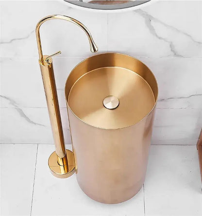 Gold-toned cylindrical pedestal standing bathtub faucet with matching tall curved spout for modern minimalist bathroom