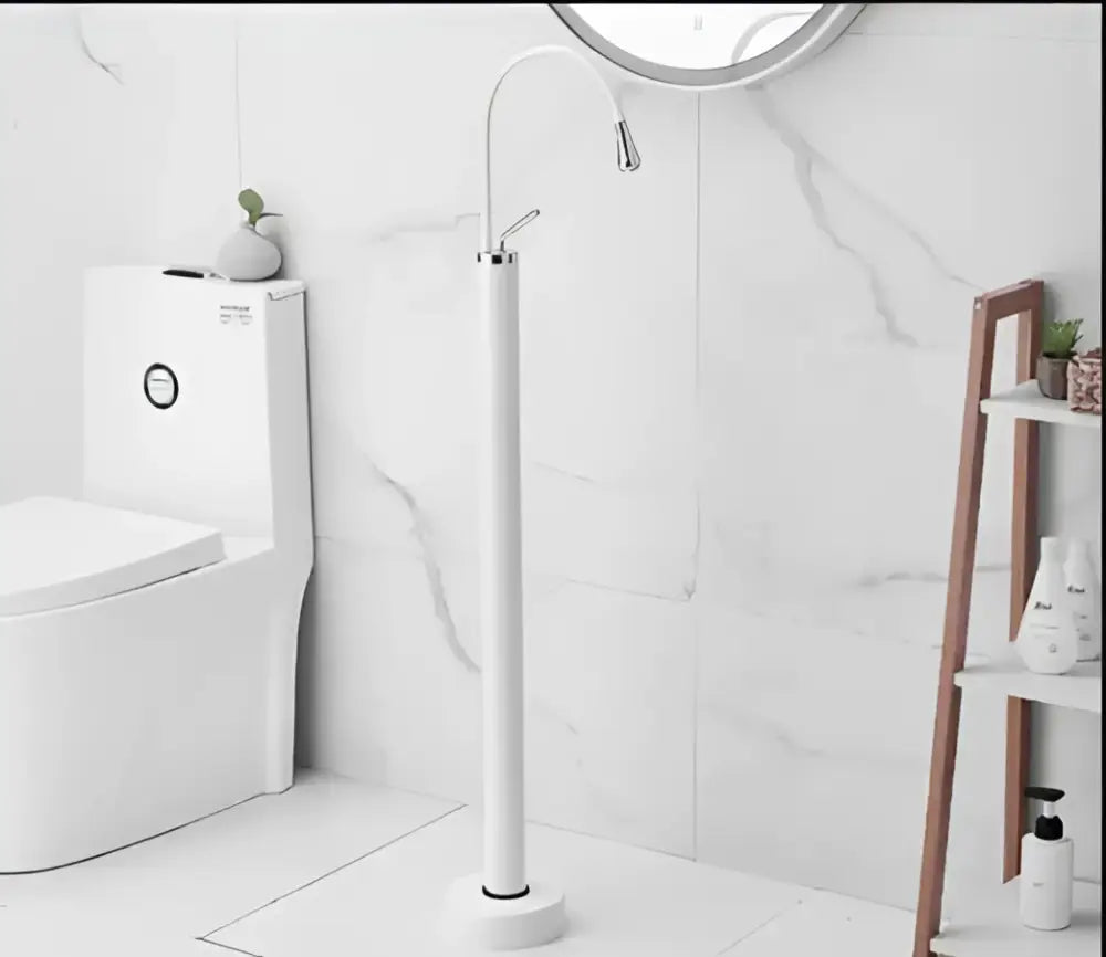 Modern minimalist white floor standing bathtub faucet with curved spout and freestanding shower head design