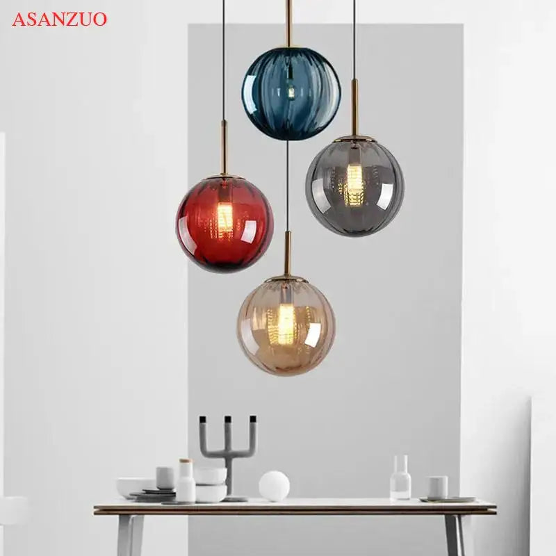 Set of four modern multi color decorbites glass ball pendant lamps in deep blue red smoky gray and amber with brass accents
