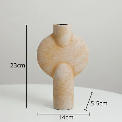 Beige textured decorbites ceramic disc vase with modern abstract shape featuring two rounded protrusions and narrow neck
