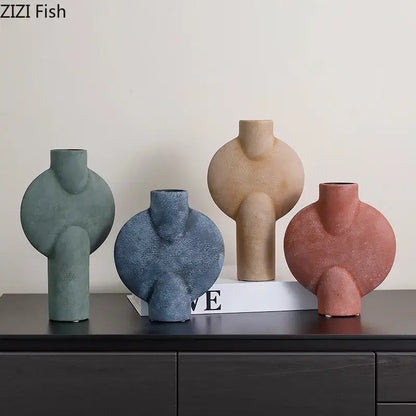 Set of four decorbites ceramic disc vases in muted green blue beige and terracotta tones with textured surfaces for living room decor