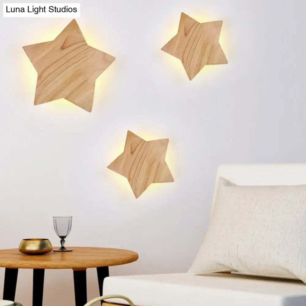 Three lighted wooden star wall lamp sconces with natural finish and visible grain for modern living room decor