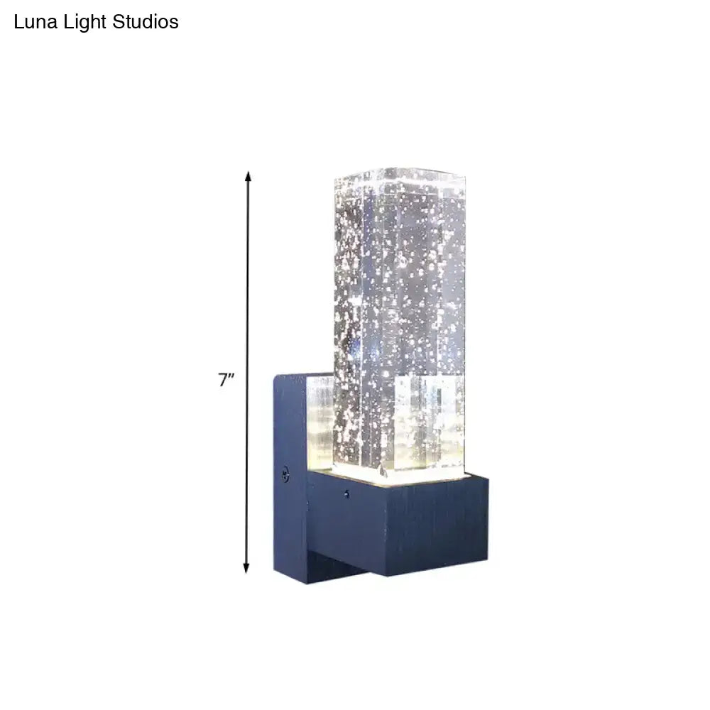 Modern navy blue wall sconce with a clear crystal bubble glass column and 7-inch fixture width for bedroom use