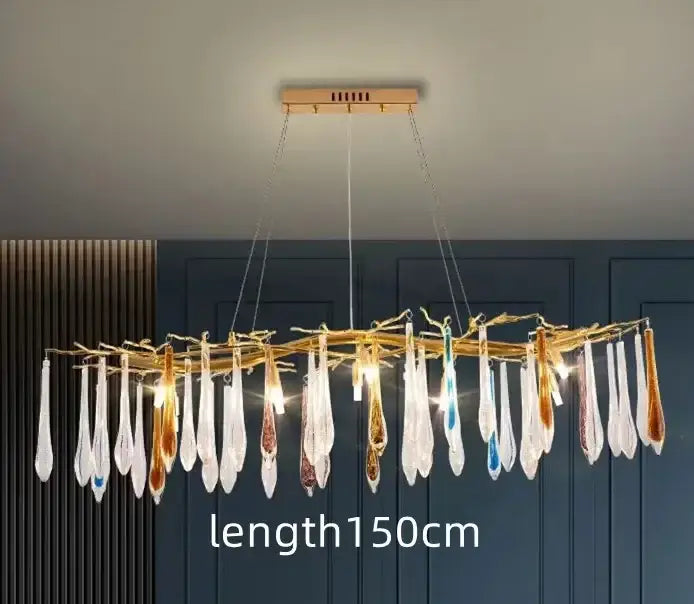 A modern nest crystal led chandelier with a golden frame and glass teardrop pendants in clear amber blue and brown hues