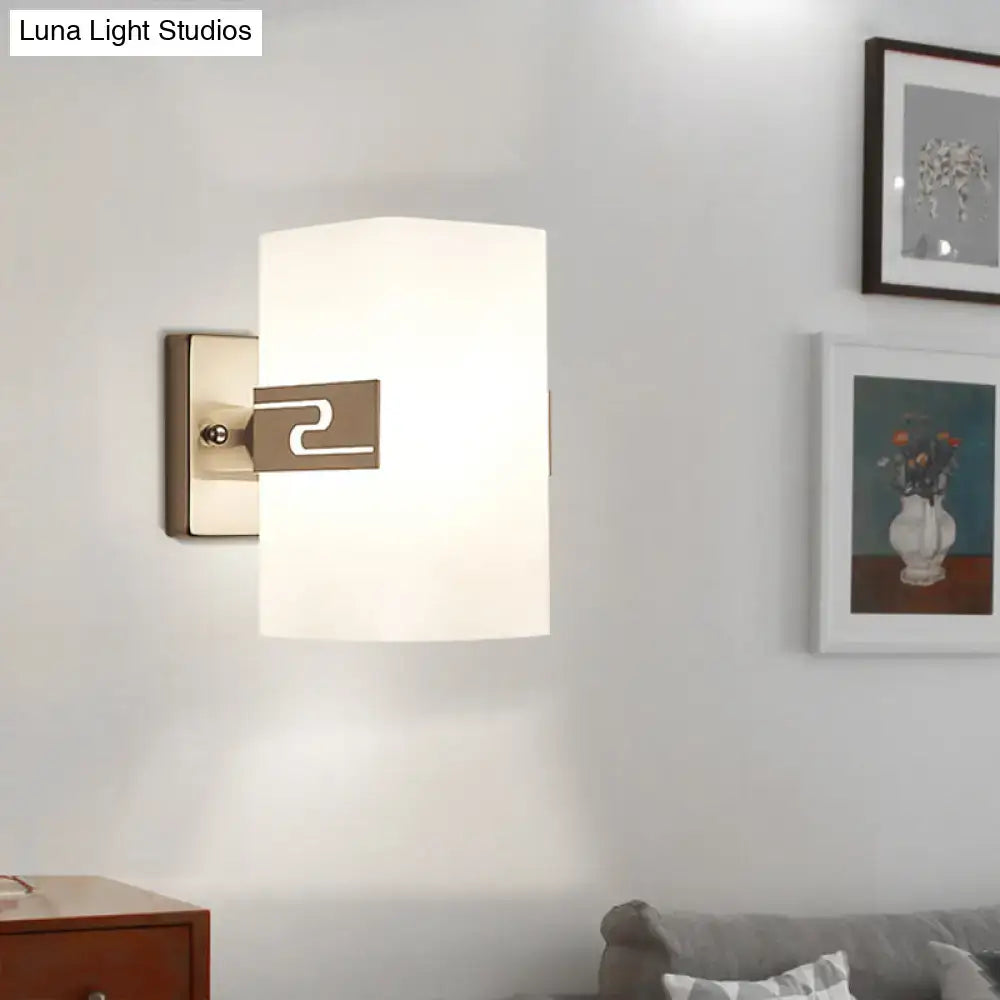 Modern nickel cuboid wall mounted sconce with a sleek brushed brass fixture and rectangular frosted glass shade for corridors