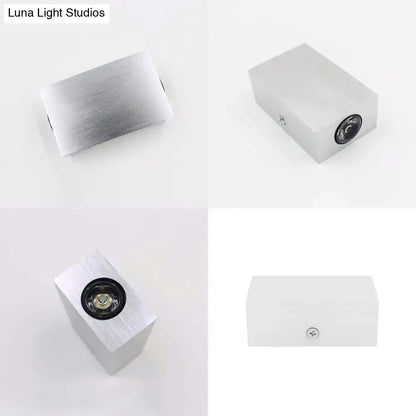 Modern nickel finish rectangular wall sconce with silver brushed aluminum, black circular lens, and visible mounting screw on side