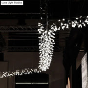 A modern aluminum island ceiling lamp with cascading white petals and nickel rose gold branching design