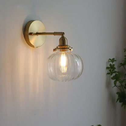 Modern nordic brass glass ball wall lamp with clear ribbed glass globe and exposed filament bulb for bedroom decorbites glass ball sconce