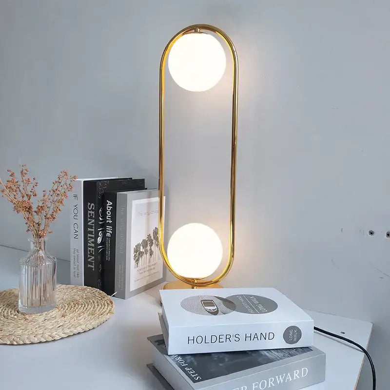 Modern nordic golden body glass led desk lamp with gold-framed oval base and two circular illuminated bulbs for decorbites golden body