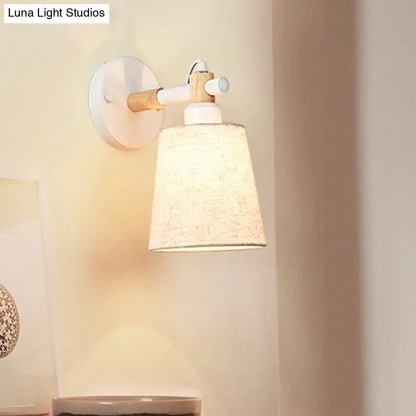 Modern nordic wood wall lamp with light wood arm and textured off-white horn shade featuring white circular base