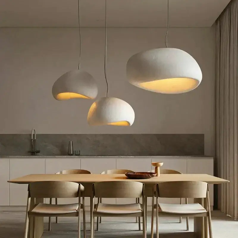 Modern off white ceramic pendant light led chandelier with warm glowing interiors hanging above wooden dining table decorbites handmade modern
