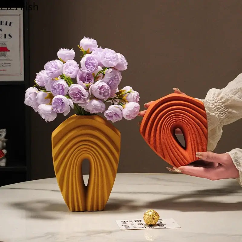 Modern orange geometric ceramic vase with sculpted arch and ridges holding light purple flowers for living room decorbites geometric ceramic use