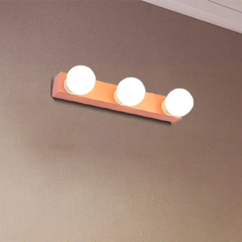 Modern orange and white rectangular vanity light fixture with three round frosted glass bulbs for bedroom use