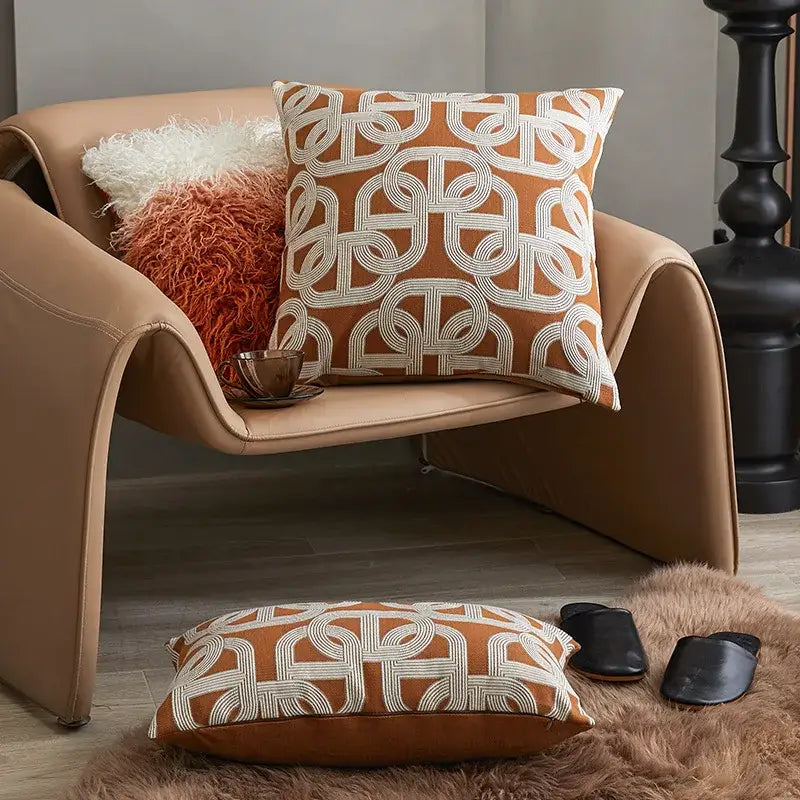 Modern orange and white jacquard crochet pillow cover with geometric pattern on tan leather armchair decorbites jacquard crochet pillow