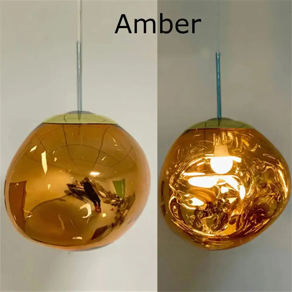 Amber-colored glossy glass pendant light with modern organic form and chrome plated finish for kitchen trio setup