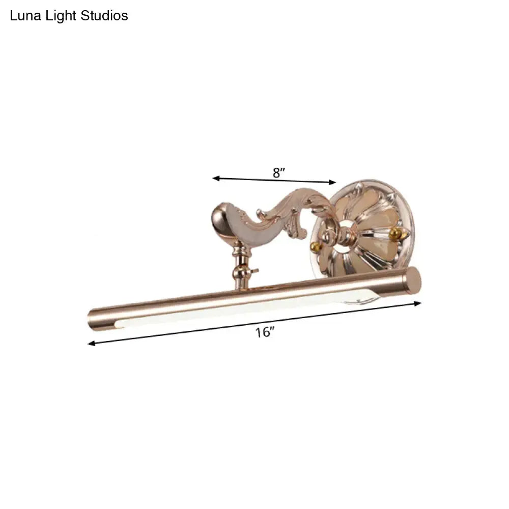A sleek brushed brass modern ornate gold floral wall mount bathroom lamp with a curved arm and cylindrical led bar
