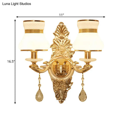 Modern ornate gold wall light with frosted glass shade featuring two cream lampshades and crystal teardrop pendants