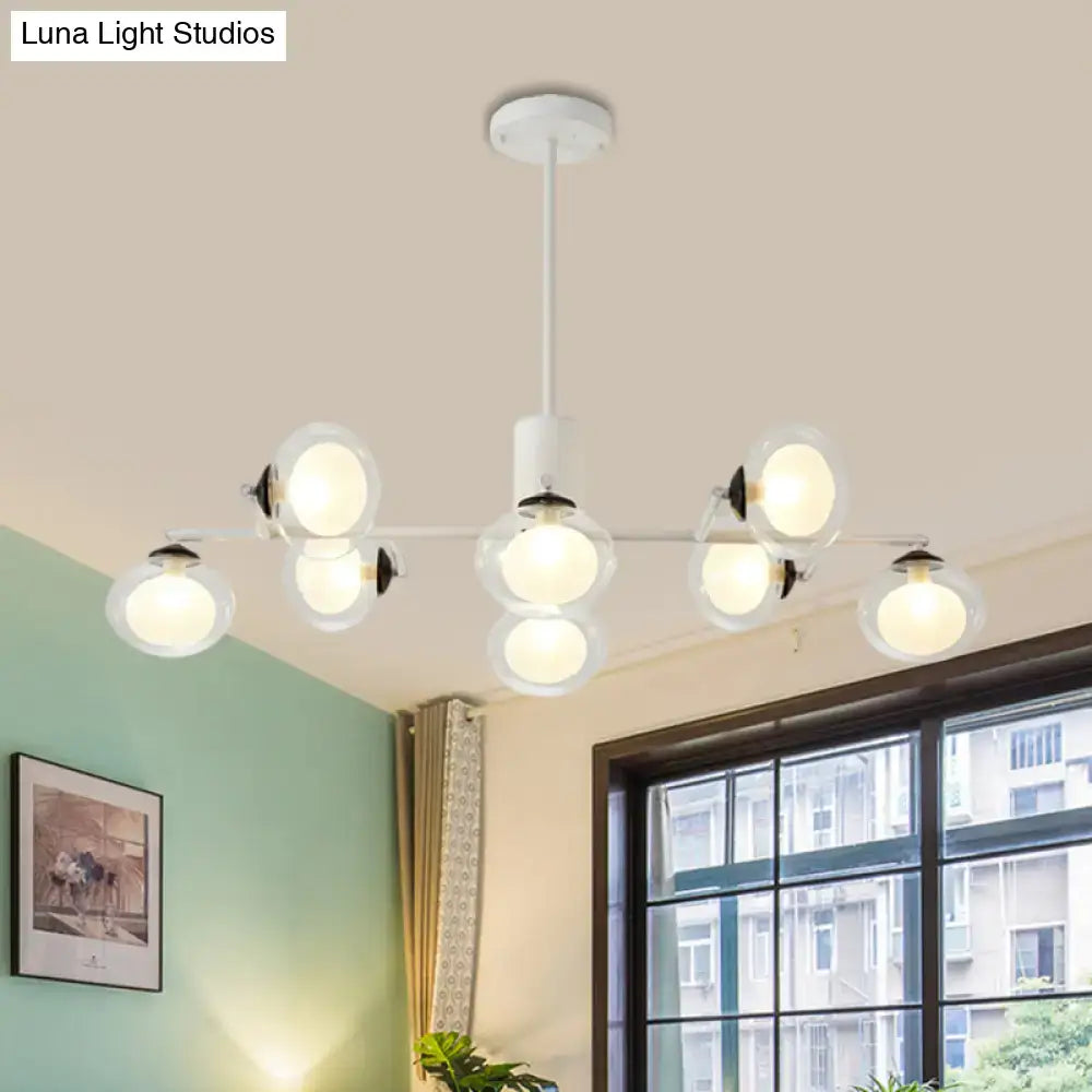 Modern white chandelier with multiple frosted glass globe bulbs and sleek black white metal arms for island lighting