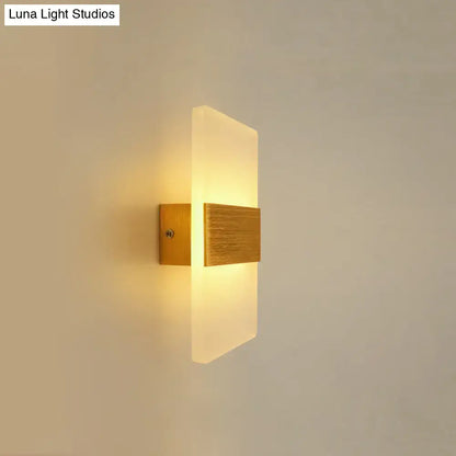 Modern oval rectangular convex led wall sconce with brushed gold metal base and frosted glass emitting warm light