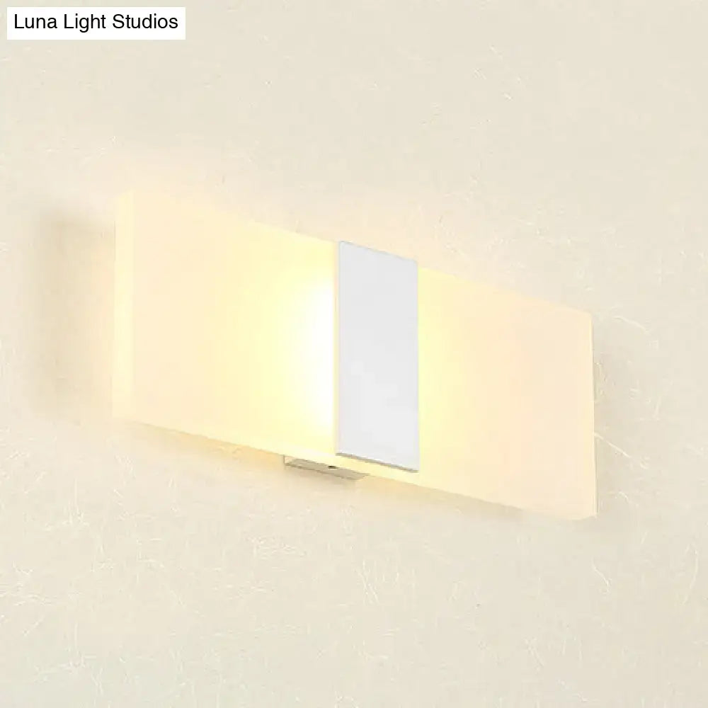 Modern oval rectangular convex wall sconce with frosted glass diffuser and metallic accent emitting warm ambient light