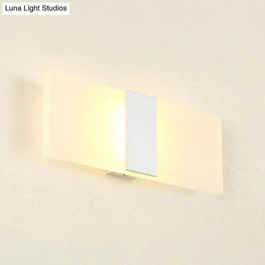 Modern oval rectangular convex wall sconce with frosted glass diffuser and metallic accent emitting warm ambient light