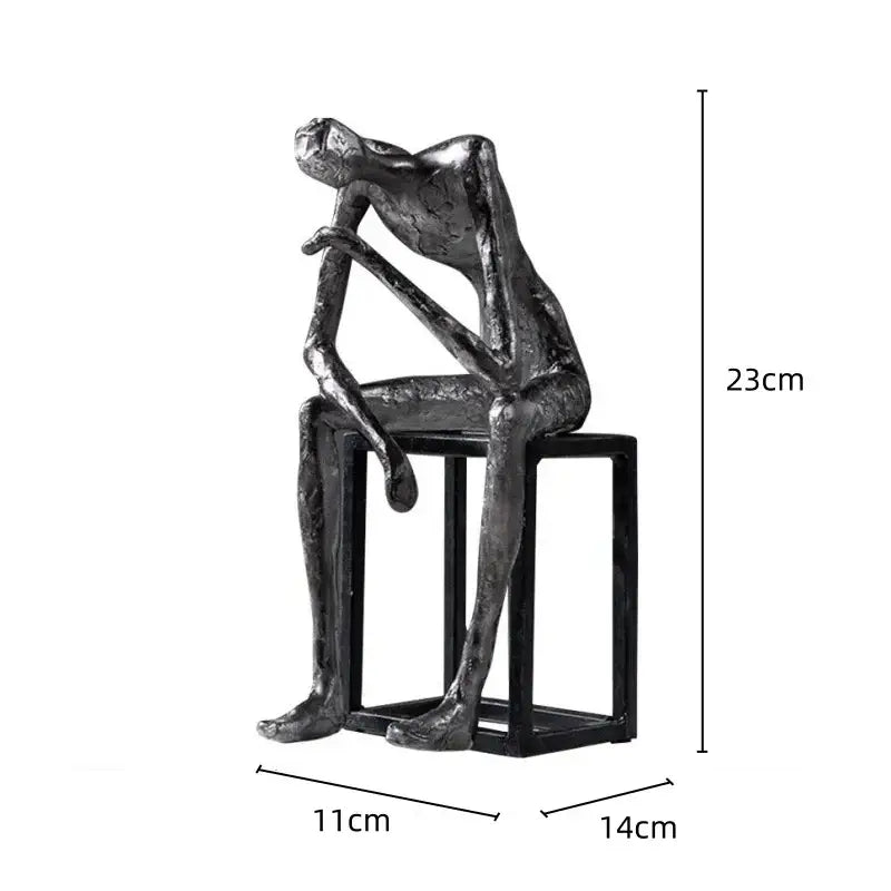 A sleek metallic modern oxidized silver abstract thinkers sculpture seated on a black stool for living room decorbites abstract thinkers