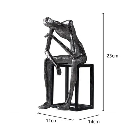 A sleek metallic modern oxidized silver abstract thinkers sculpture seated on a black stool for living room decorbites abstract thinkers