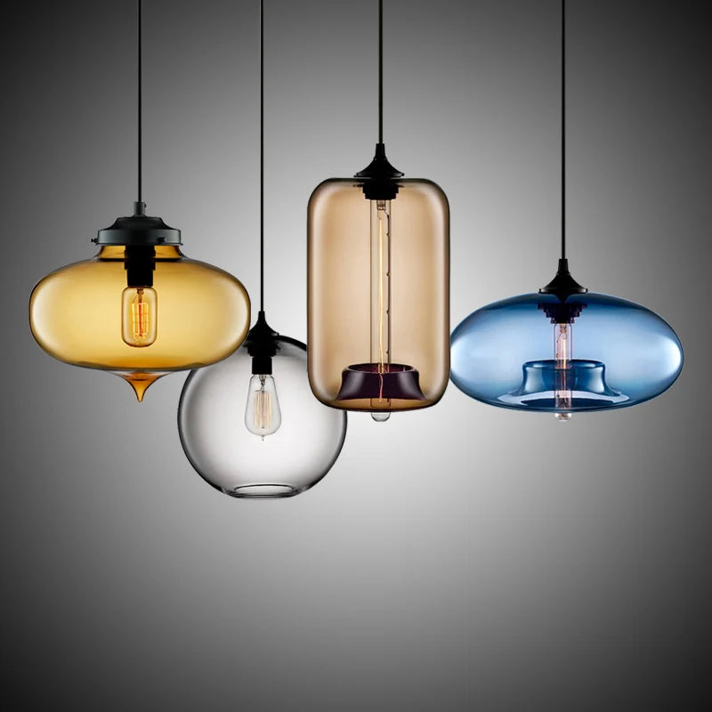 Set of modern pendant lights with amber smoked brown and blue glass and exposed filament bulbs for dining and loft decor