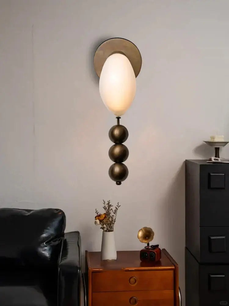 Modern wall lamp with frosted white oval glass shade and three dark bronze spheres for decorbites brass curve glass design